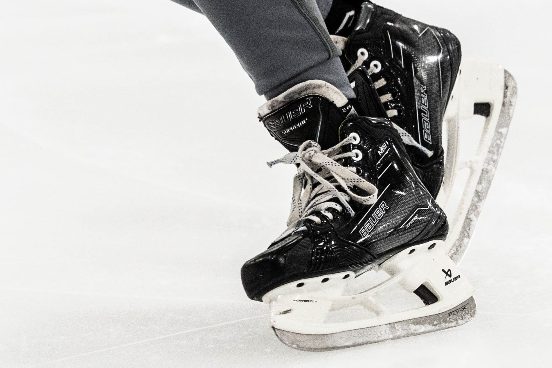 Close-up of hockey skates carving into the ice